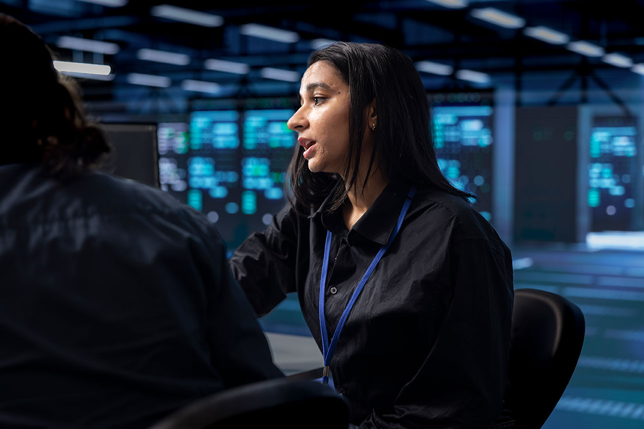 Computer scientist and coworker monitoring security